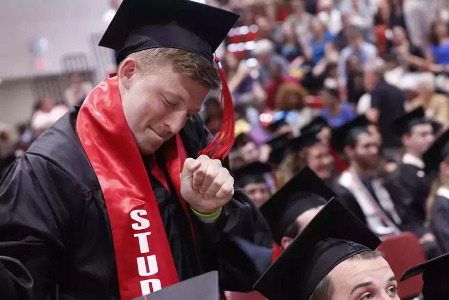 Student dancing in their cap in gown at graduation.