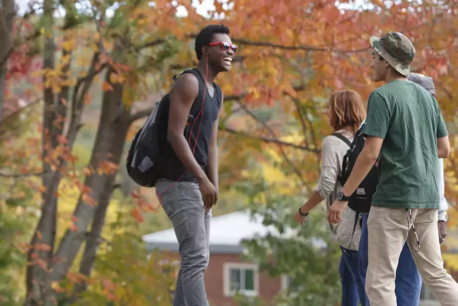 Students talking while walking around campus on a Fall day.