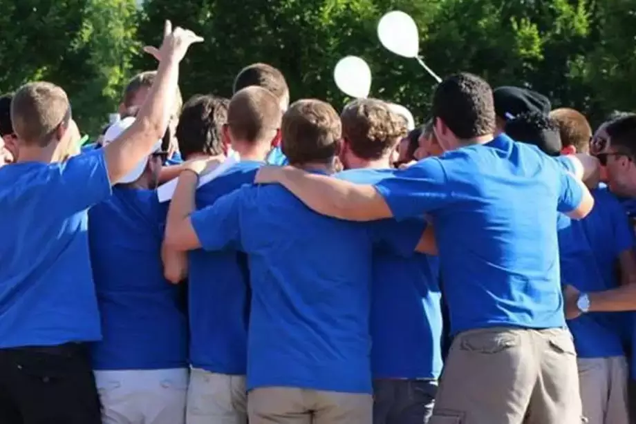 Group of students welcoming a new member to their Greek organization.