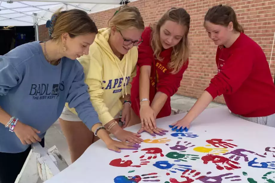 Students Place Painted Hand Prints on the WIngs