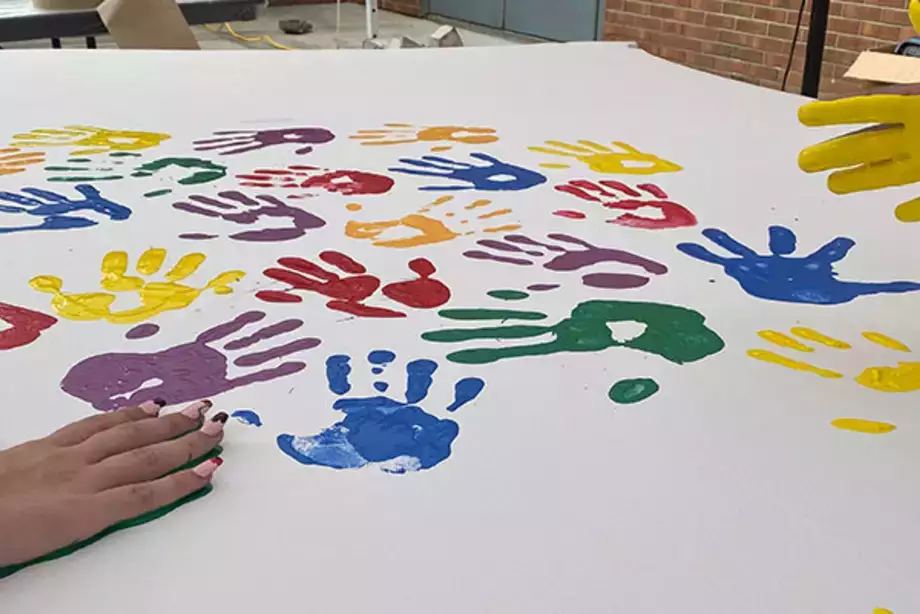 Students Place Painted Hand Prints on the WIngs