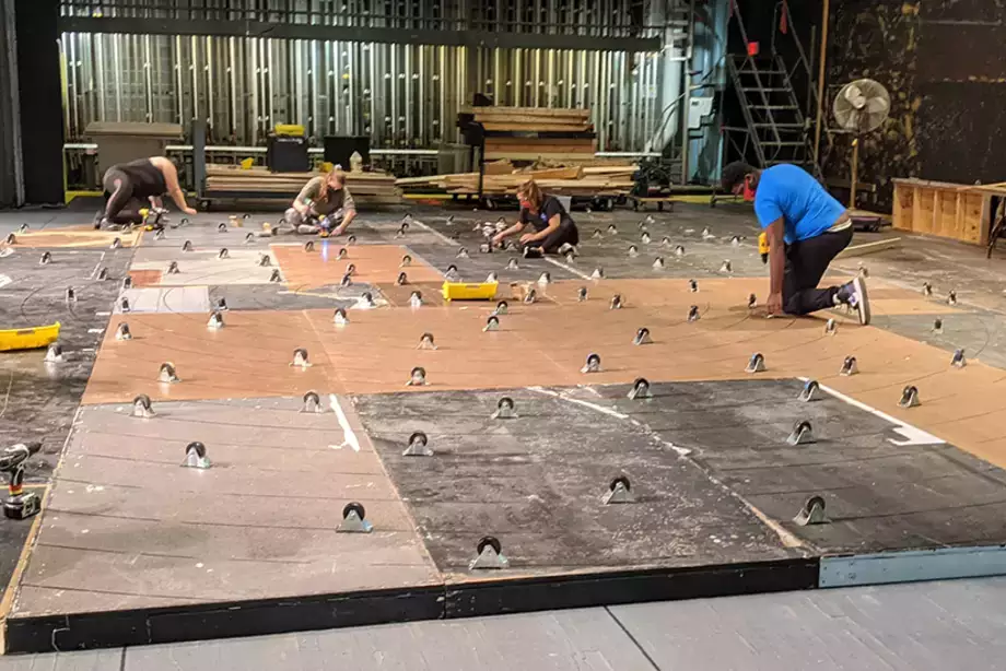 Students fix casters on the bottom of a rotating set