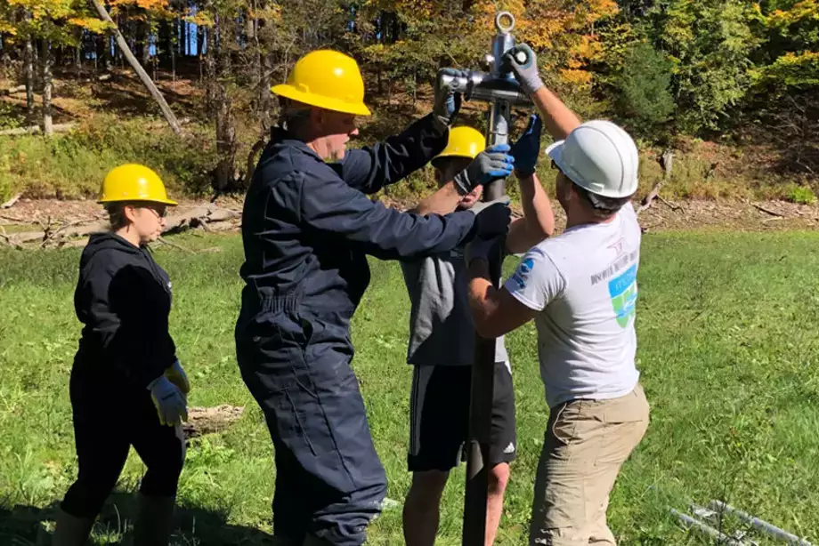 Geology students and faculty coring into muds of Lower Reservoir while drained