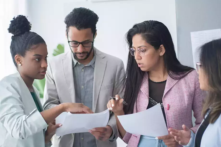 Four people discussing a report or other communication