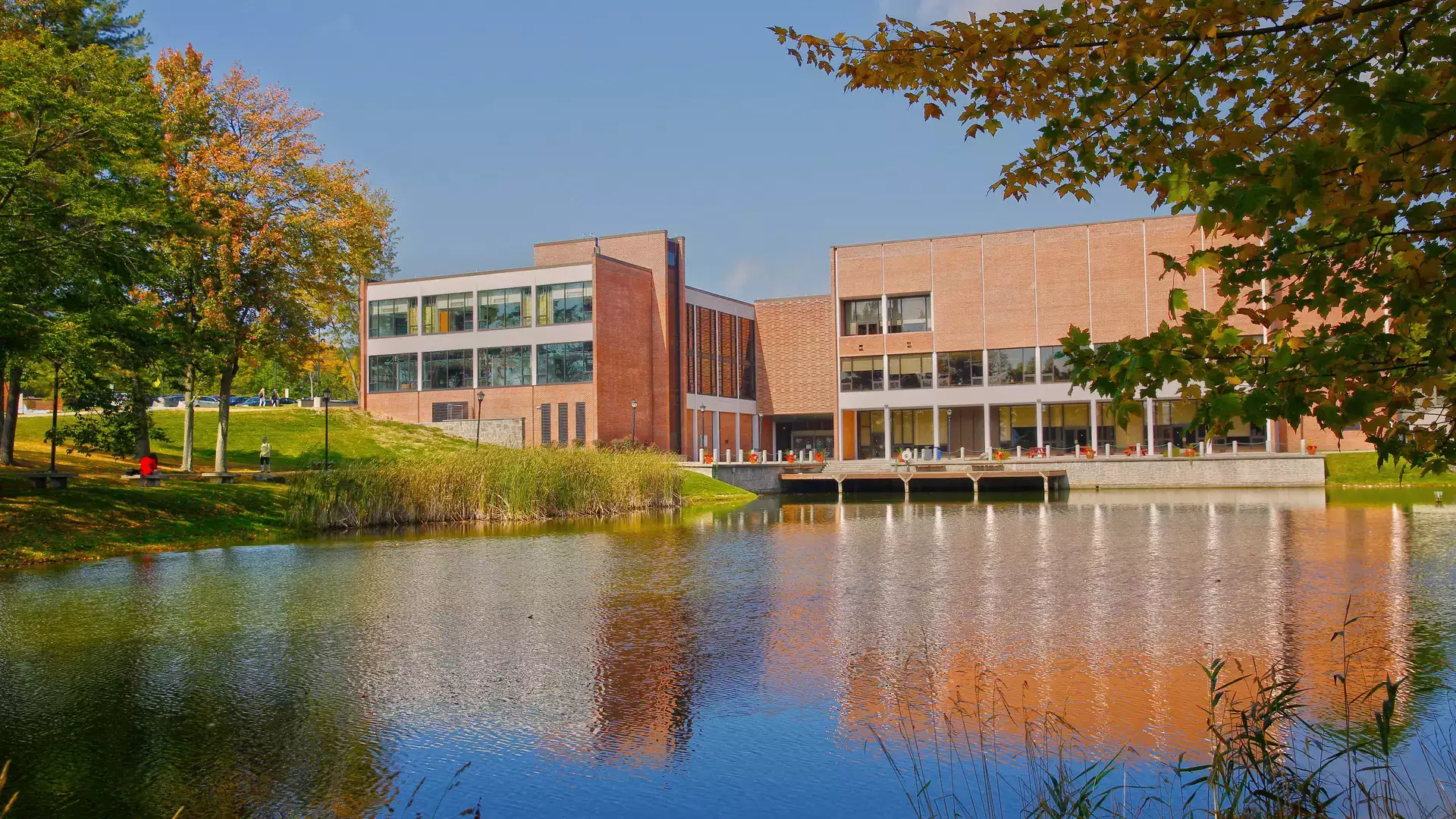 A fall season view of Hunt Union reflected across the pond