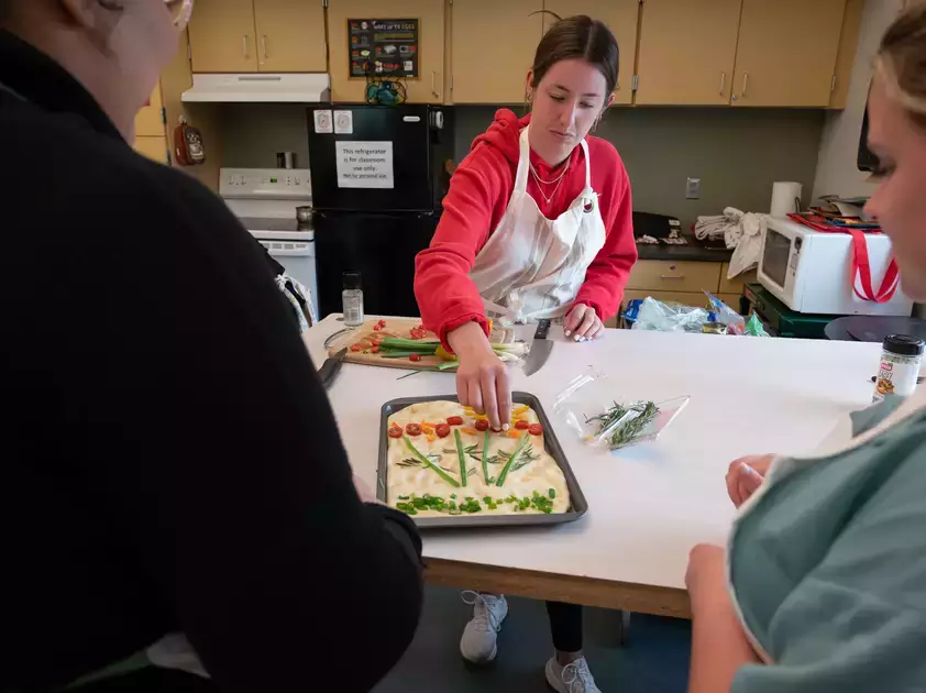 Students watch as a tray of focaccia is prepared. 