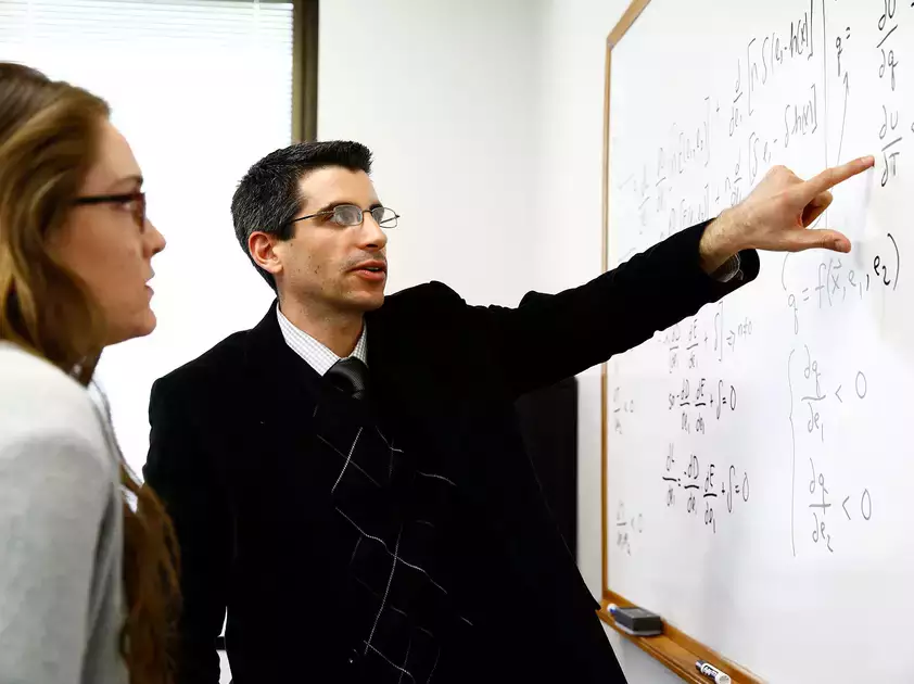 Philip Sirianni, assistant professor of economics, meets with student Mariel Doyle to discuss her research project