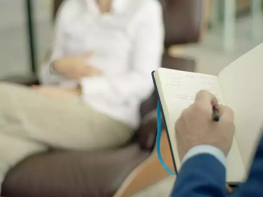 Counselor takes notes during a session