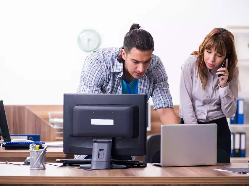 IT Desktop support representative assisting a coworker