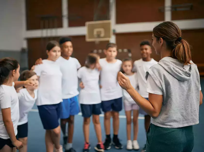 A coach speaks to her class during physical education